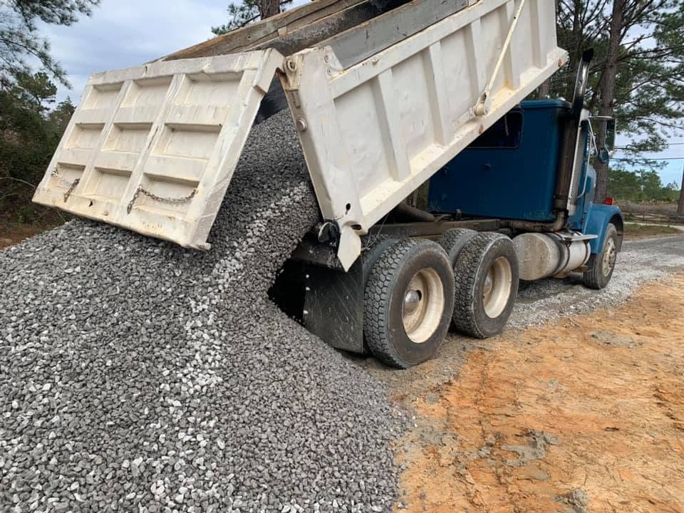Dump truck spreading a load of crushed gravel